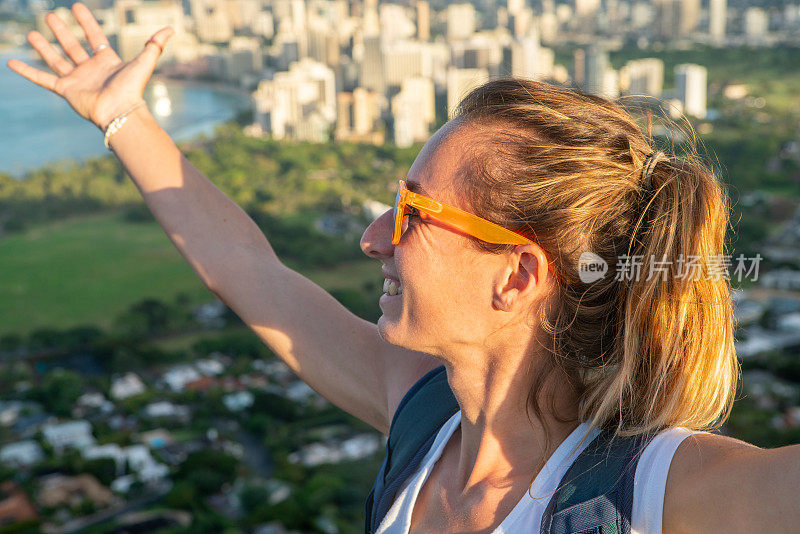 美国夏威夷檀香山，一位年轻女子在山顶上张开双臂