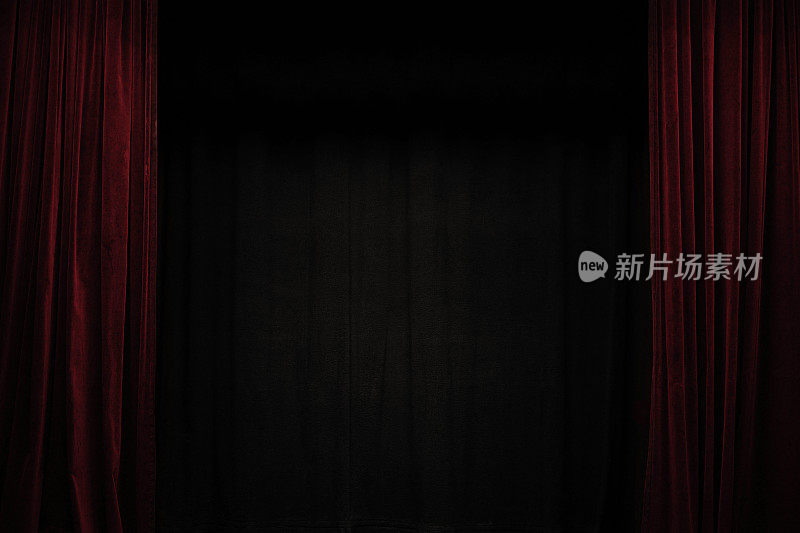 非常深的红色天鹅绒窗帘在一个黑色剧场舞台的侧面，背景框架与大的复制空间