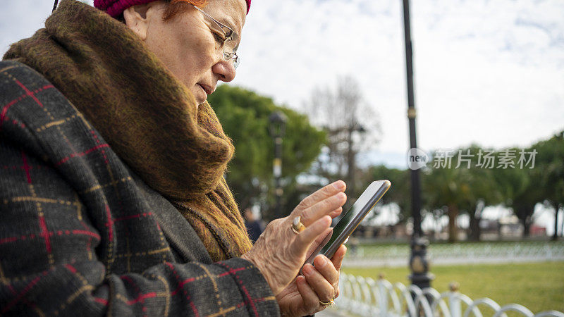 成熟的女人在街上用手机