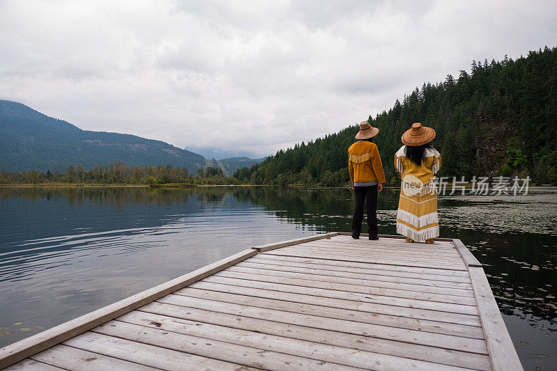 两个穿着传统服装的原住民妇女在湖边