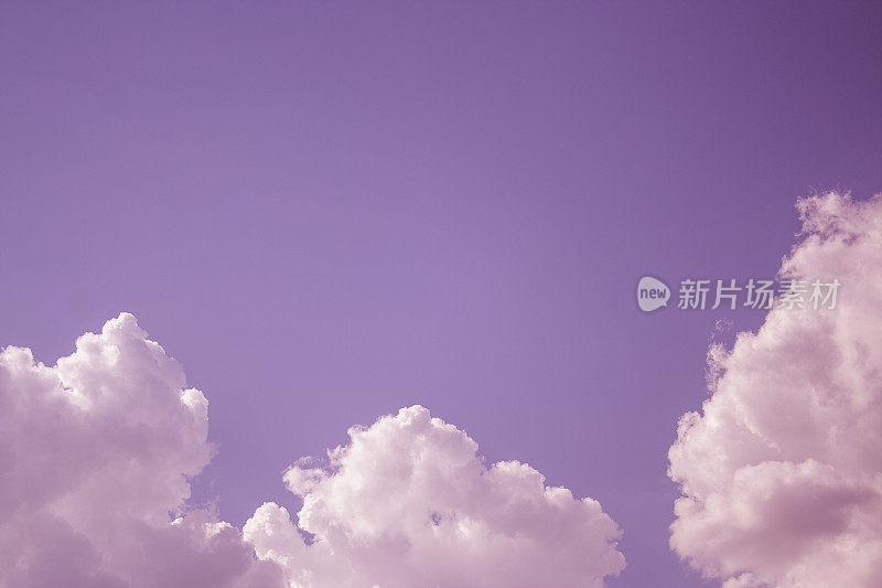 在多风的冬日里，白色的云高高地挂在天空中，背景色调是紫色的