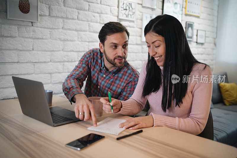 一对深情的年轻夫妇用他们的笔记本电脑做家庭预算