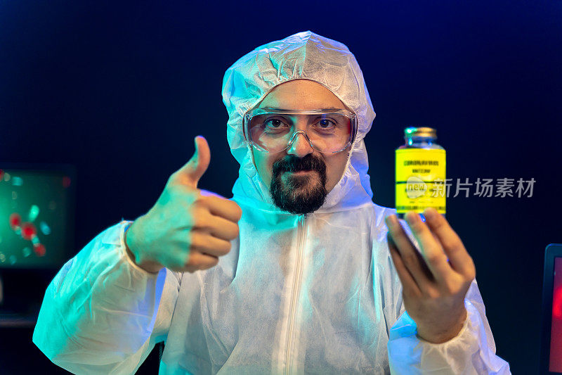 实验室科学家在实验室展示冠状病毒疫苗瓶，并竖起大拇指，情绪积极