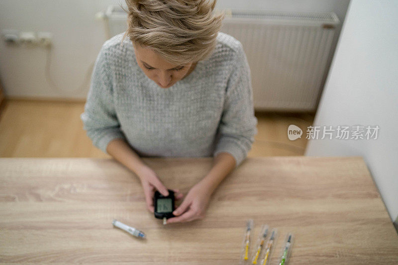 年轻女性糖尿病患者近距离用血糖仪掐手指测量工作场所的血糖水平，不健康女性手持手术刀用血糖仪检查胰岛素做试验，健康问题观念