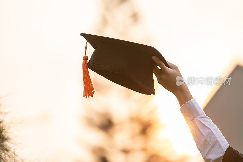 毕业典礼上，研究生举起手，戴着毕业帽庆祝，感觉如此幸福，毕业典礼上祝贺学生，教育成功理念