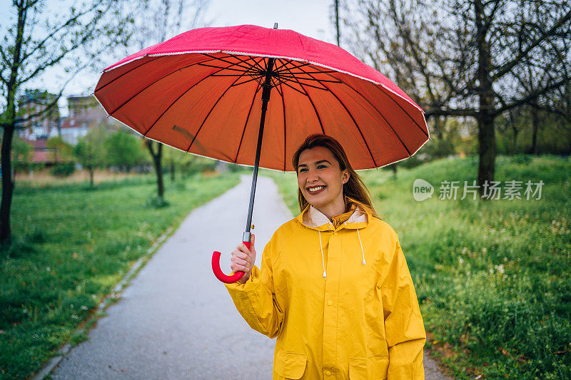 拿着红伞站在外面淋雨的女人