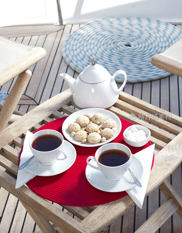 游艇甲板上的一壶热茶和一盘饼干。