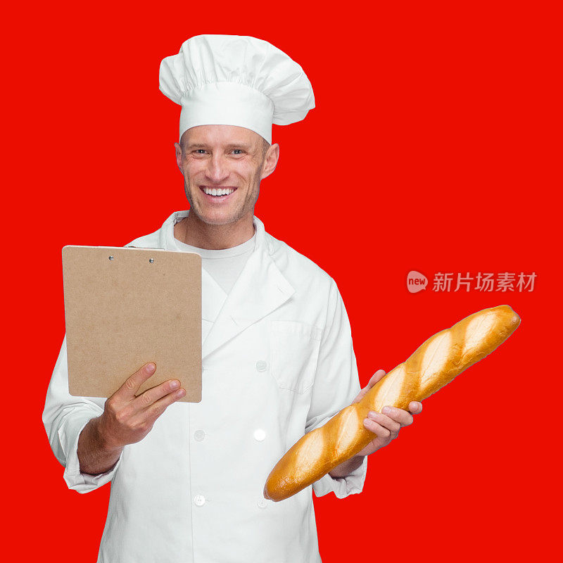 白人年轻男性面包师在有色背景下穿着裤子，拿着要做的清单