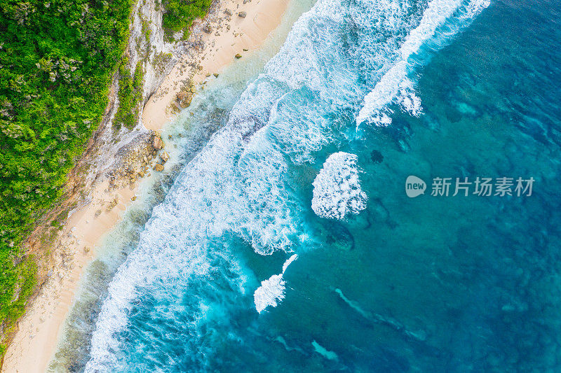 蓝色的海洋和被热带植物覆盖的悬崖。从上面看巴厘岛海岸。空中无人机拍摄。