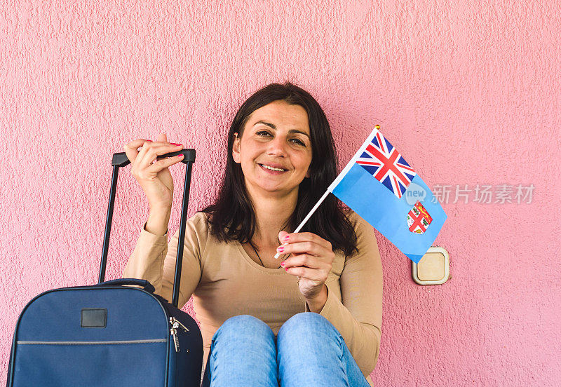 拿着旅行袋和斐济国旗的女人