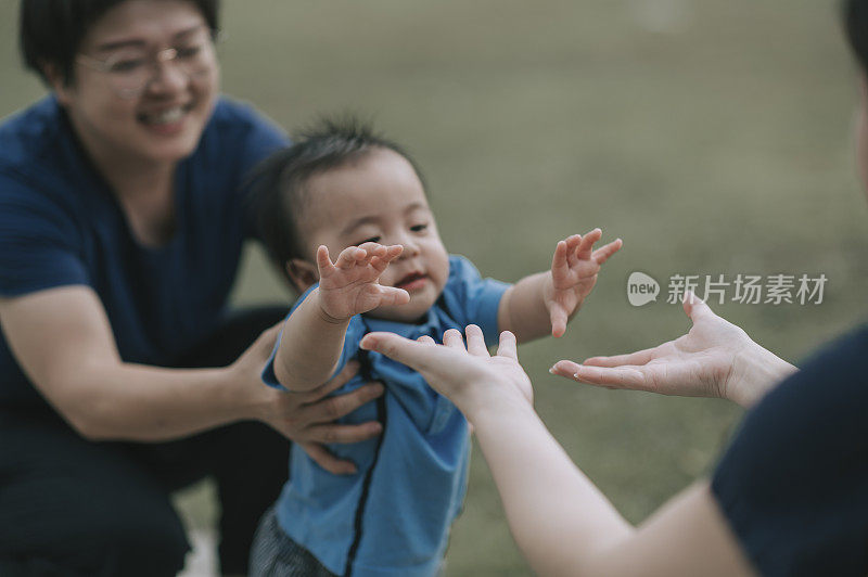 亚洲华人家庭教小男孩在公园迈出第一步