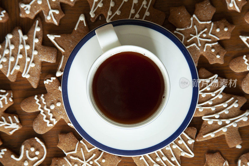 一杯茶，上面放着圣诞姜饼，星星，树，雪形状的饼干。