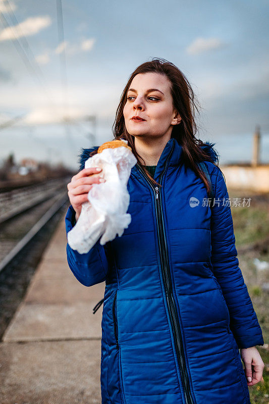 女人边等车边吃东西