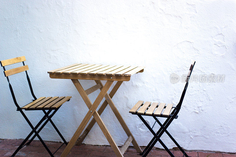 空咖啡桌与两把椅子，白色石膏墙背景
