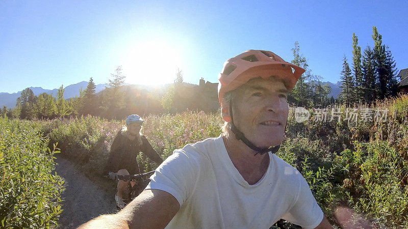 一对骑电动自行车的夫妇穿过郁郁葱葱的高山草甸