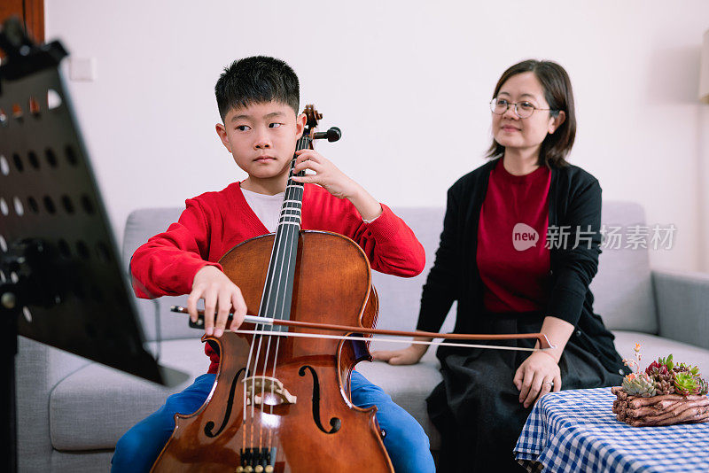 小男孩在家跟老师练习大提琴