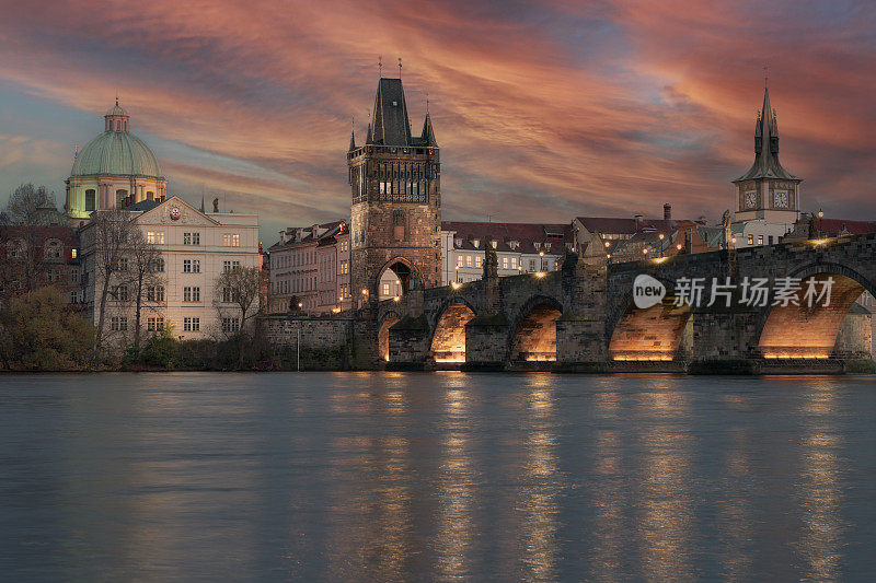 14世纪的查理大桥，街灯和桥上的石雕，以及布拉格伏尔塔瓦河水面上夜晚的灯光反射