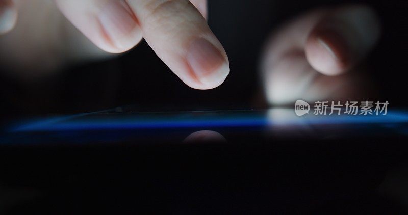 在使用手机时，人的手在智能手机屏幕上移动。极端特写镜头