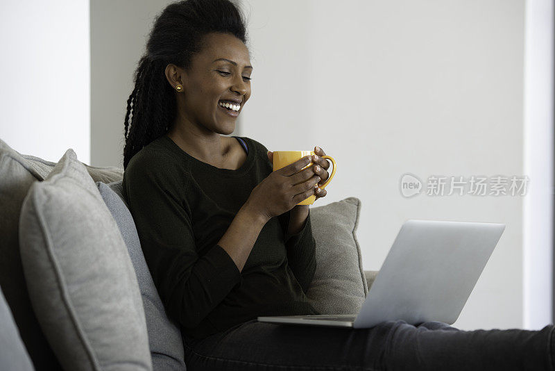 在家工作。女人在网上视频通话，喝着热饮。