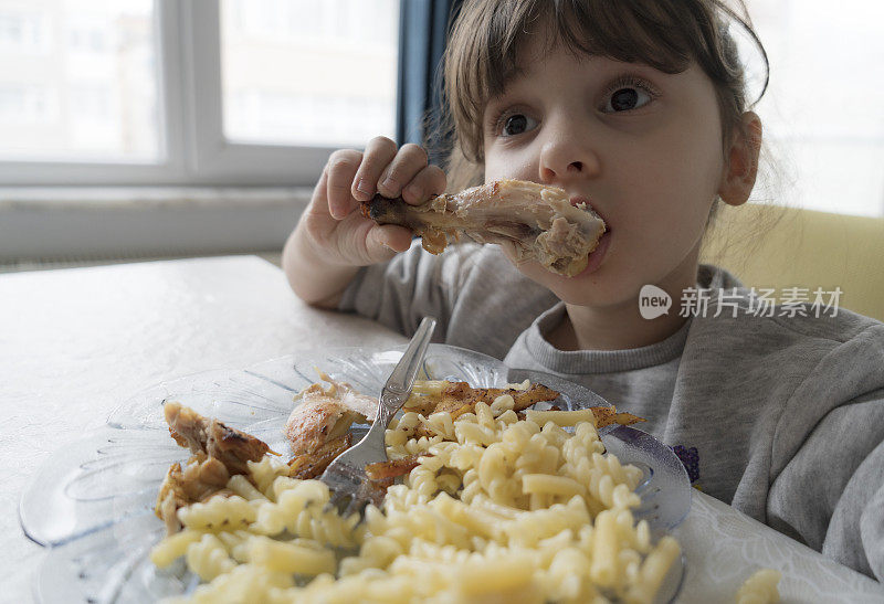 小女孩正在吃鸡肉