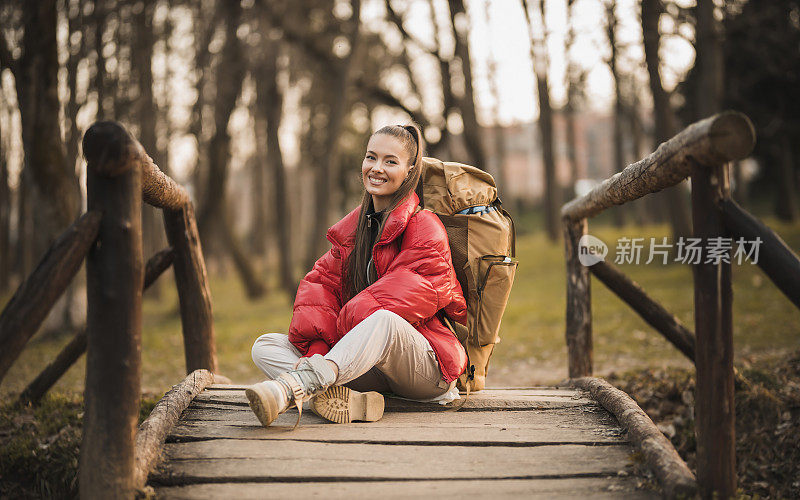 成功的女人徒步登山在日出的山顶-年轻的女人背包上升到山顶。发现旅游目的地