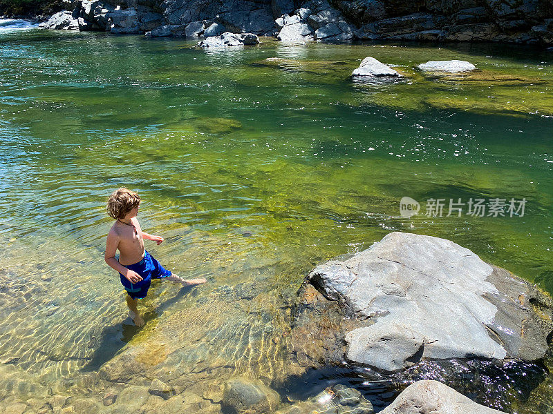 孩子们在一条美丽的绿色河里玩耍和游泳。