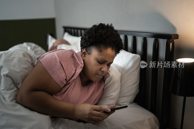 女人在床上看手机
