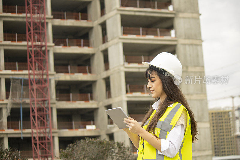 女建筑师在建筑工地与数字平板电脑