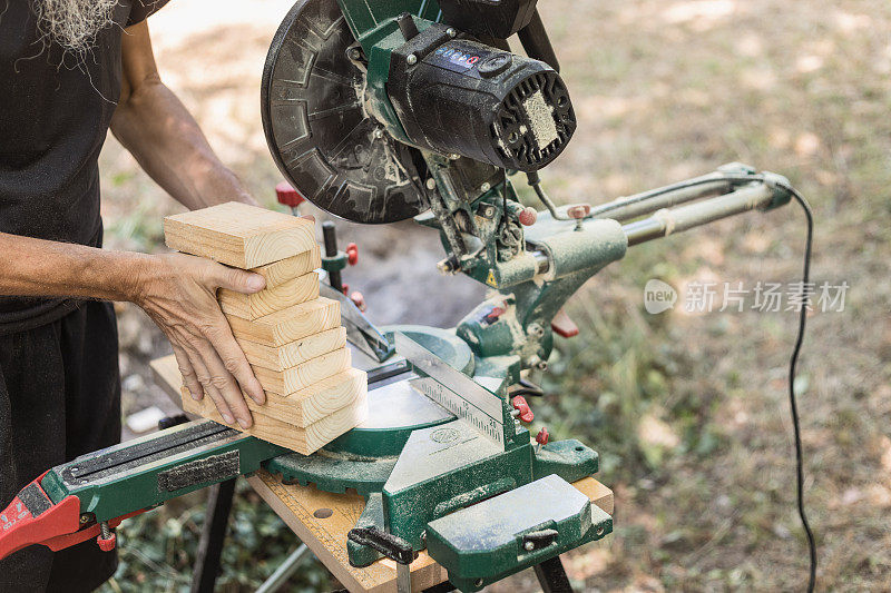 手艺人持有一堆木刻切割使用人字锯