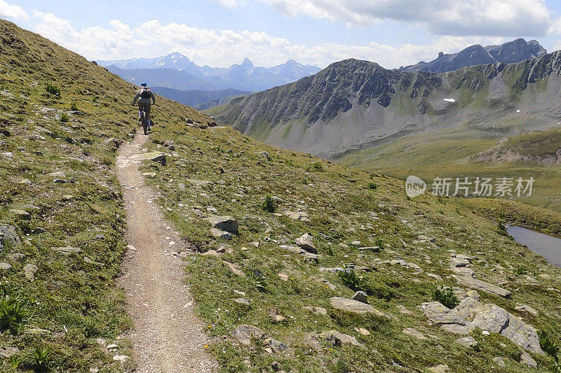 一名女子沿着阳光明媚的山脊骑山地车