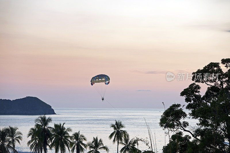 在哥斯达黎加，太阳落山时，Parasailor创造了日落的剪影