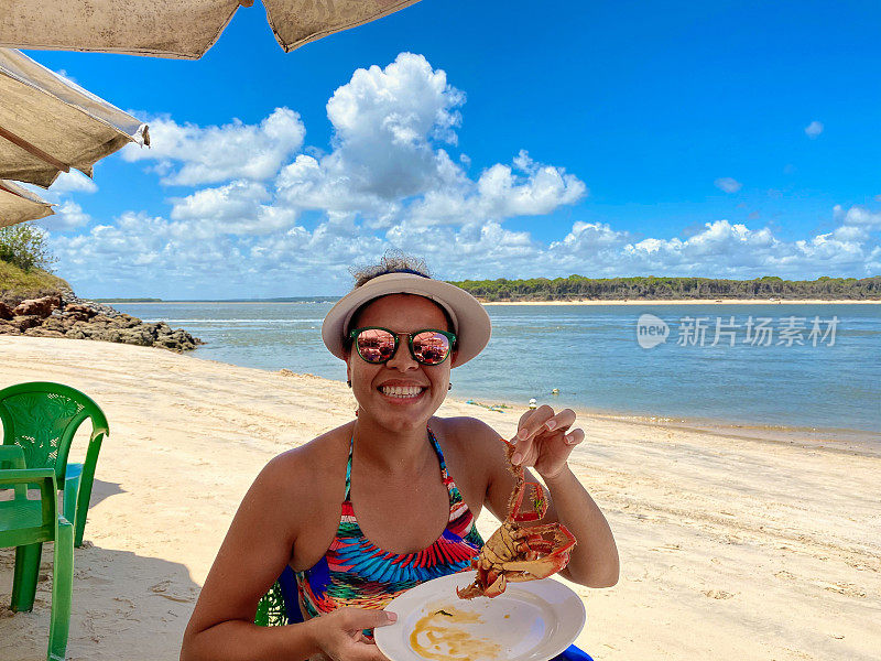 在海滩上吃螃蟹的女人