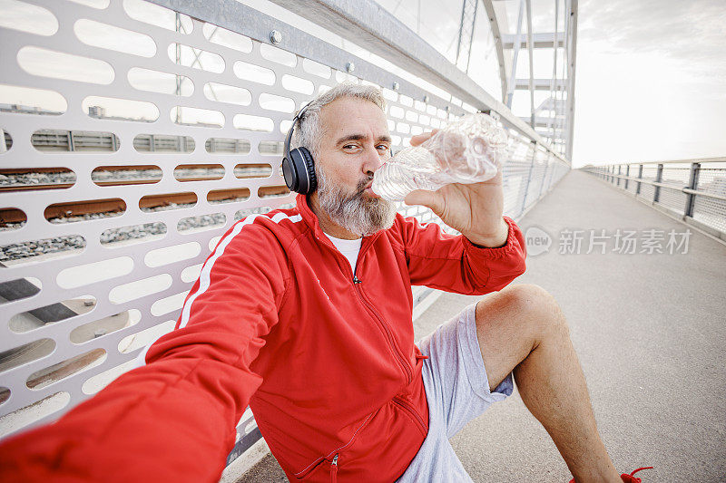 成年男子在户外高强度运动后喝水和休息的自画像