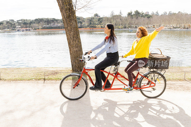 一对母女在公园里全速骑着双人自行车