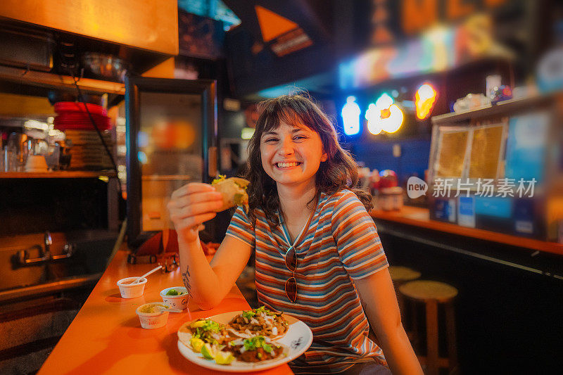 一个女人在酒吧里吃玉米卷