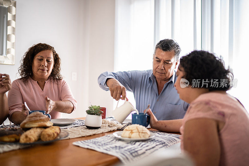 一家人在家里吃早餐——包括一个精神运动迟缓的女孩