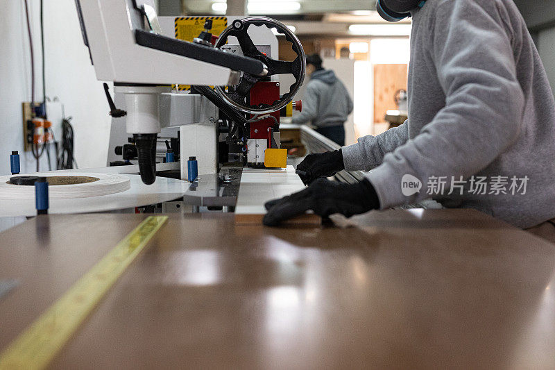 木材工厂的工人测量和切割木贴面板