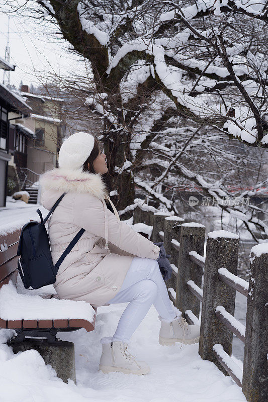 美丽的女子游客享受他们的日本之旅在雪的冬天。