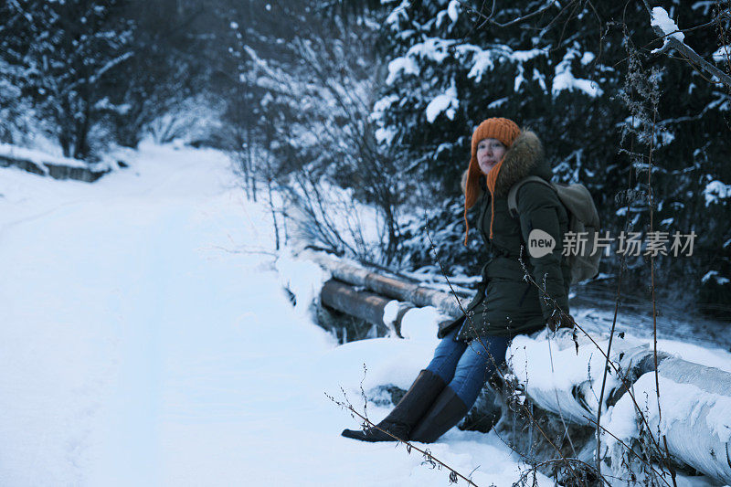 成熟的女人在冬天的山路上等待