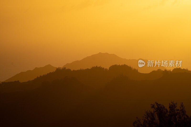 令人惊叹的雾蒙蒙的山景在金色的日落