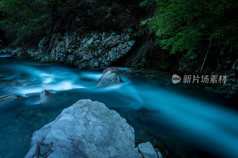 在黄昏时分，河流在山上急速流动。