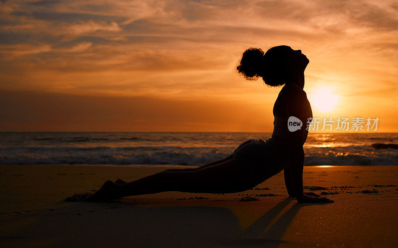 日落瑜伽，健身和一个女人的剪影在海滩上进行正念训练。冥想，禅宗和女孩在晚上在海边伸展普拉提姿势进行精神锻炼