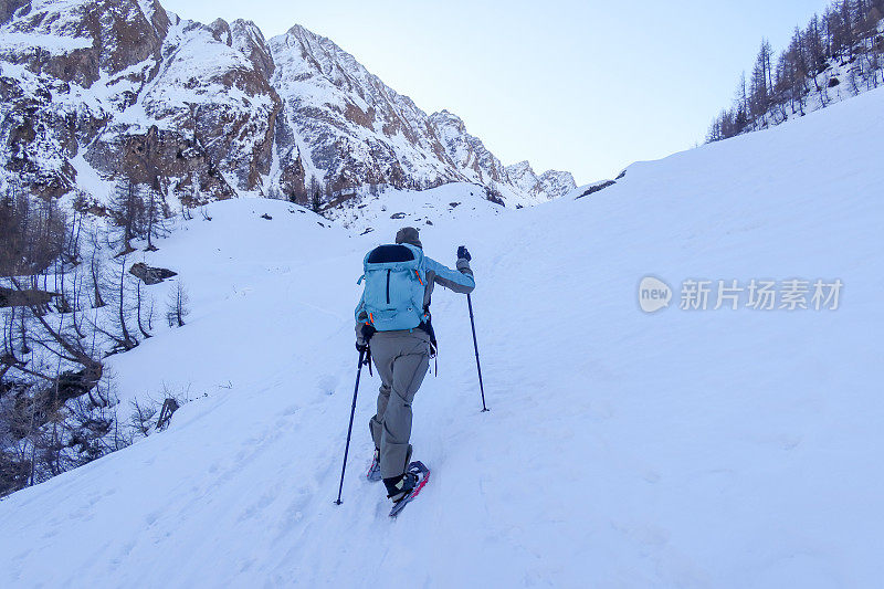 年轻女子在瑞士阿尔卑斯山的冬天穿雪鞋