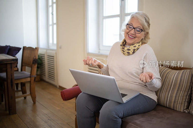 一位老妇人正在使用笔记本电脑