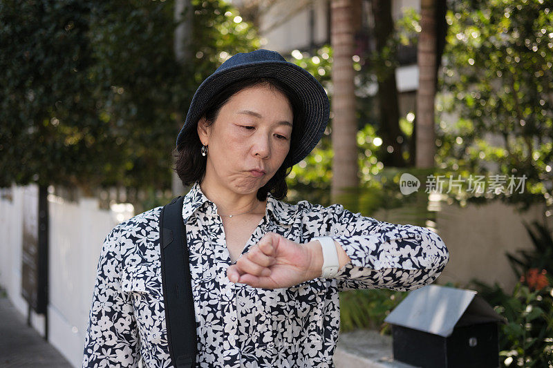 心烦意乱的女人在外面看表