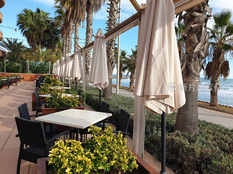 西班牙锡切斯，空荡荡的夏日咖啡馆露台，可以看到海景