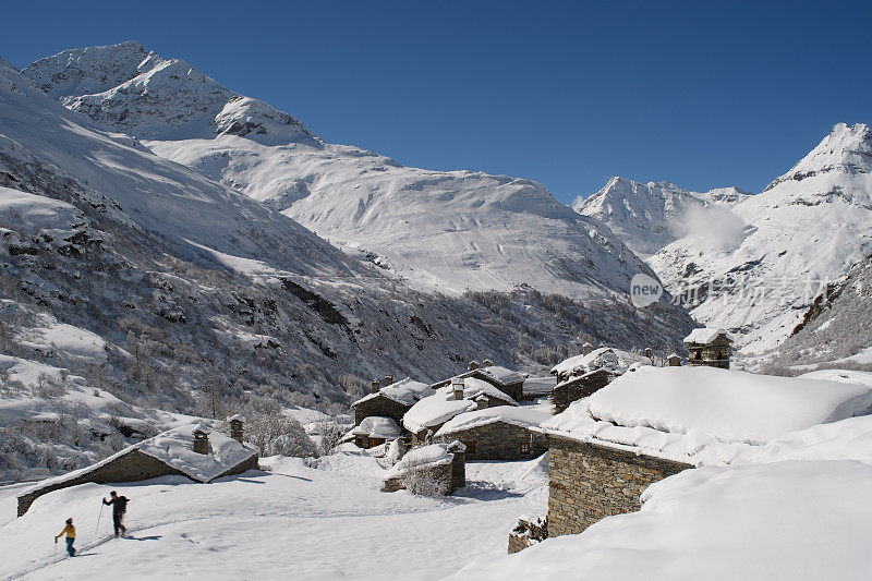 两个模糊的剪影在阿尔卑斯山Ecot村的滑雪板上