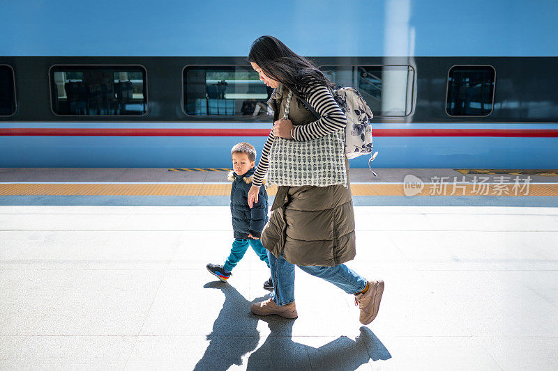 有趣的休息:多种族小孩和中国妈妈在蓝色火车上