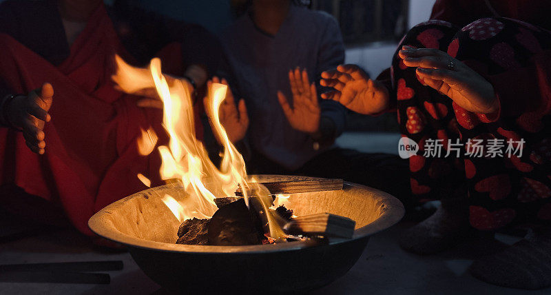 冬天，人们围坐在家里的篝火旁取暖。