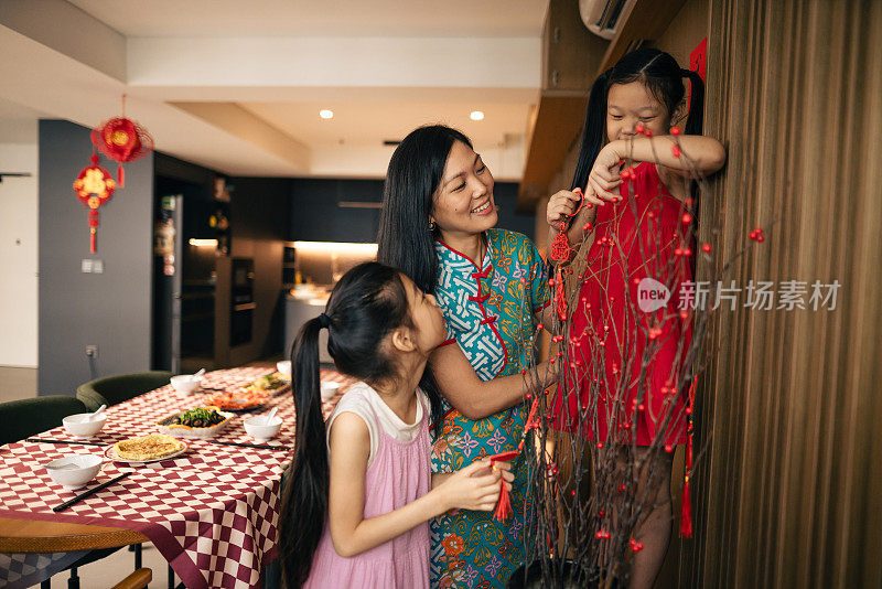 一位中国母亲和她的女儿们正在为中国新年制作装饰品